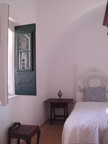 a bedroom with a bed and a table and a window at Casa Marina Olhao in Olhão