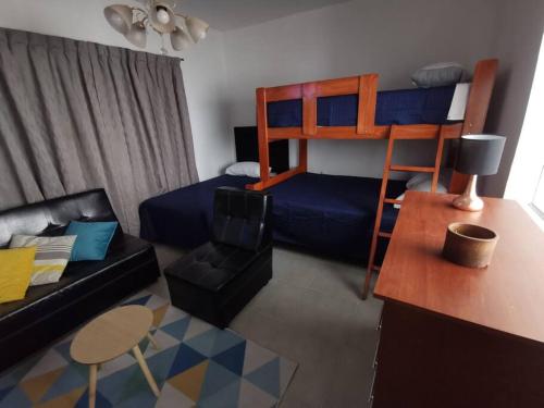 Cómodo y bonito departamento في Santa Rosa: غرفة معيشة مع سرير بطابقين وأريكة