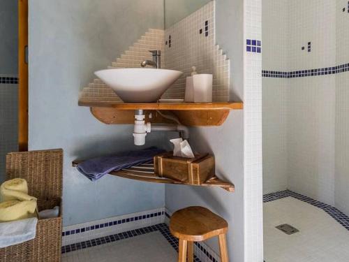 ein Badezimmer mit einem Waschbecken auf einem Regal und einem Hocker in der Unterkunft Rustique, Confort et Détente Près de Nantes: Chambre Équipée avec Petit-Déjeuner Inclus - FR-1-306-1254 in Bouvron