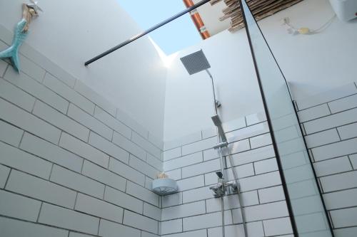 a bathroom with white subway tiles and a shower at Hideaway Batukaras in Pangandaran