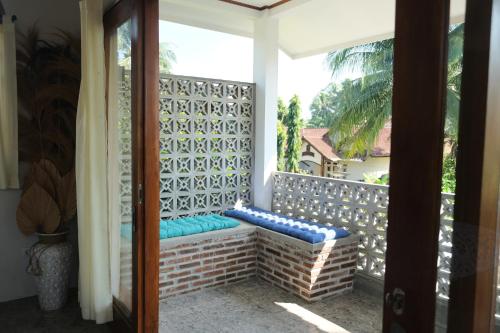 un porche con un banco en el balcón en Hideaway Batukaras en Pangandaran