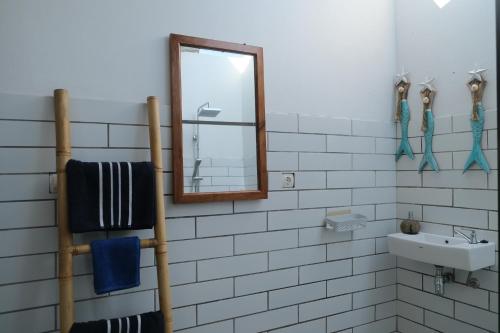 a bathroom with a mirror and a sink and towels at Hideaway Batukaras in Pangandaran