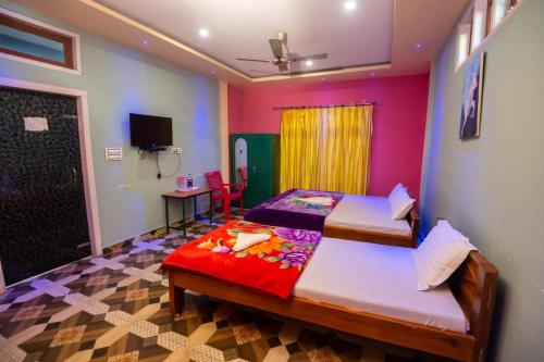 een slaapkamer met 2 bedden en een tv. bij JUNGLE STAR MANSION in Kāziranga