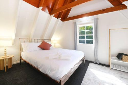a bedroom with a bed with white sheets and a window at Winding Creek Cottage in Bald Knob
