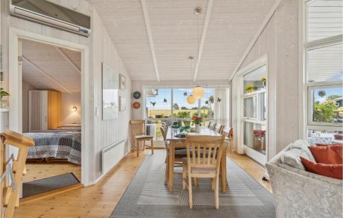 un comedor con mesa y sillas y un dormitorio en Beautiful Home In Rudkbing With 3 Bedrooms, Sauna And Wifi, en Spodsbjerg