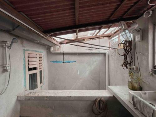 ein Badezimmer mit Fenster und Waschbecken in einem Zimmer in der Unterkunft Artist Heritage Penang UNESCO Home (Lebuh Armenian) in George Town