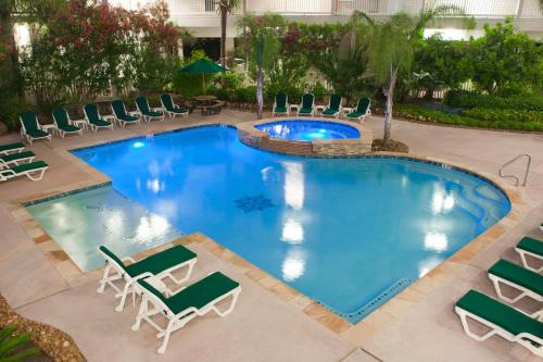an overhead view of a pool with chaise lounge chairs and a resort at Beachfront View Condo at Casa Del Mar in Galveston