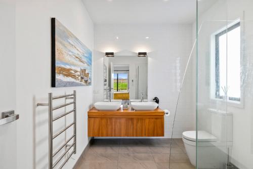 a bathroom with two sinks and a mirror at Sandhill Beach House - Te Horo Holiday Home in Te Horo