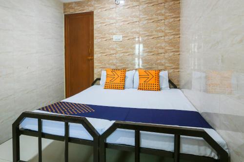 una camera da letto con un letto con cuscini arancioni e blu di OYO Hotel Prince Residency a Vellore
