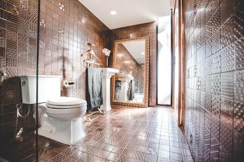 a bathroom with a toilet and a mirror at Art Mai Gallery Nimman Hotel Chiang Mai in Chiang Mai