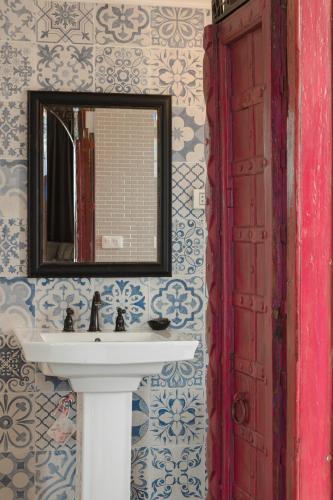 a bathroom with a sink and a mirror at Art Mai Gallery Nimman Hotel Chiang Mai in Chiang Mai