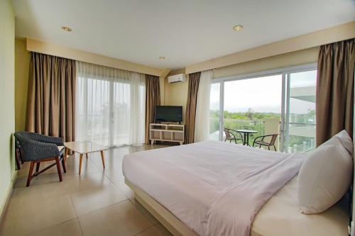 a bedroom with a bed and a balcony with a television at Dafam Resort Belitung in Tanjungbinga