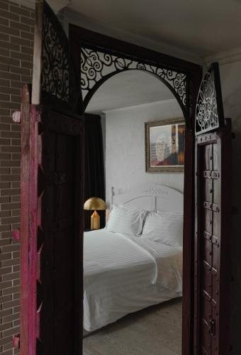 a bedroom with a large bed with an open door at Art Mai Gallery Nimman Hotel Chiang Mai in Chiang Mai