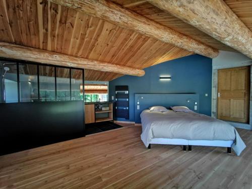een slaapkamer met een bed en een houten plafond bij Séjour champêtre : magnifique ferme réhabilitée avec piscine, terrasses et confort moderne à St Étienne Lardeyrol - FR-1-582-389 in Saint-Étienne-Lardeyrol