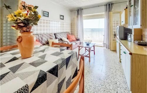 a kitchen and living room with a table with a vase on it at Stunning Apartment In Santa Pola in Santa Pola