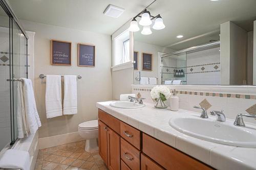 uma casa de banho com 2 lavatórios, um WC e um espelho. em Exquisite Central Townhome with Spacious Loft and Gourmet Kitchen em Seattle