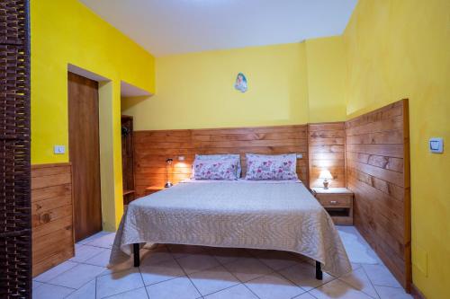 a bedroom with a bed and a yellow wall at The Hamlet and the Valley, Il Paesino e la Vallata in Foiano della Chiana
