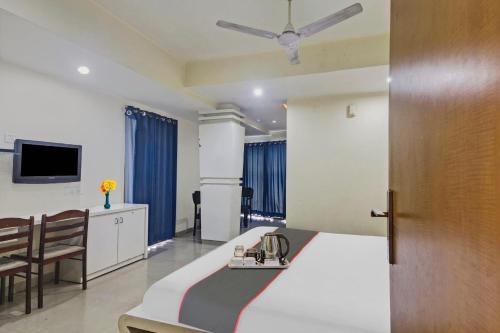 a hotel room with a bed and a table and chairs at Collection O THE CROWN HOTEL in Hyderabad