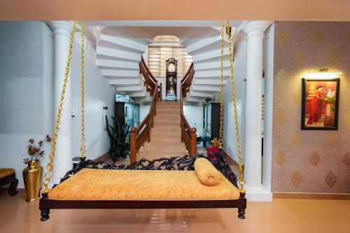1 dormitorio con cama colgante y escalera en Parudeesa - Kerala, en Kāladi