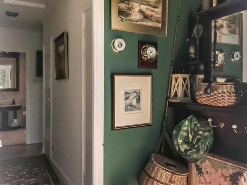 a hallway with a green wall with pictures on it at An Tabhall in Glencripesdale