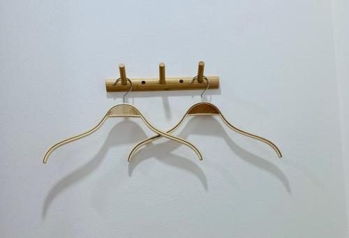 a wooden rack with two hangers on a wall at Suanvadee Resort สวนวดี รีสอร์ท in Don Sak