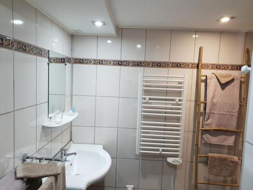 Guestroom Ventron, 2 pièces, 4 personnes - FR-1-589-543 في فينترون: حمام أبيض مع حوض ودش