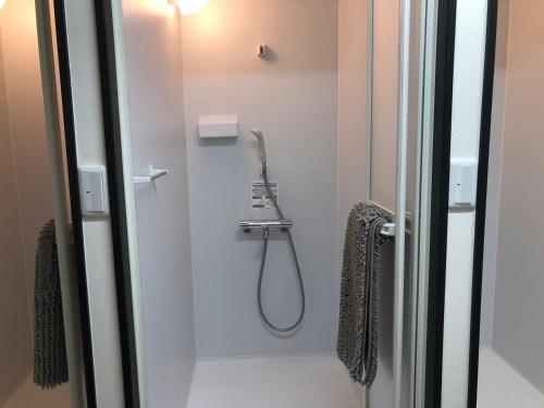 a shower with a shower head in a bathroom at SWELL in Hyuga