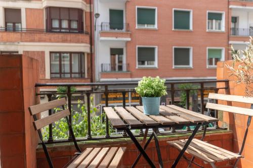 a wooden table with a potted plant on a balcony at Spacious and lovely in the City Center of Bilbao in Bilbao