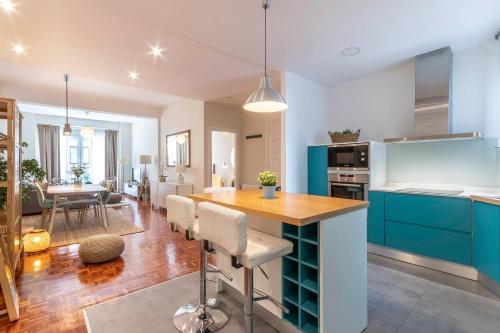 a kitchen and living room with blue cabinets and a table at Spacious and lovely in the City Center of Bilbao in Bilbao