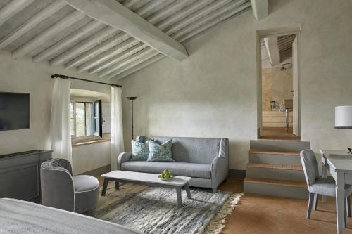 a living room with a couch and a table at COMO Castello Del Nero in Tavarnelle in Val di Pesa