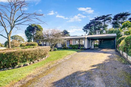 a house with a garage and a driveway at Yering Park Cottage in Coldstream