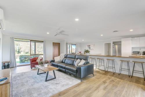 a living room with a couch and a kitchen at Yering Park Cottage in Coldstream
