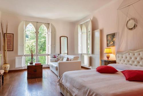 a bedroom with a bed and a couch and windows at Il Casale Di Villa Rossi in Lucca