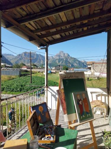 a group of paintings on a table with a view of mountains at Art Vila Galeri in Kazbegi