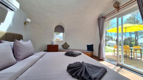 a bedroom with a bed and a large sliding glass door at Romdoul Kirirom Resort in Kampong Speu