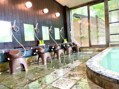 a swimming pool with benches and a row of mirrors at Lake Side Nikko Hotel in Nikko
