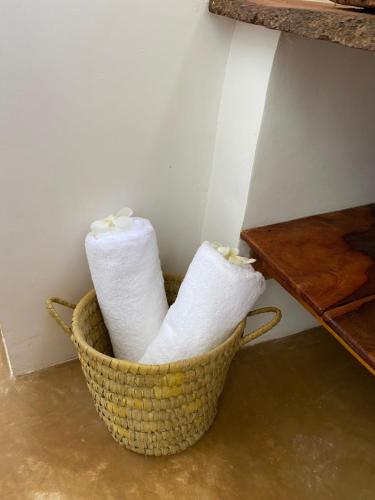 dos rollos de papel higiénico en una cesta junto a una mesa en Baobab Africa Lodge Zanzibar en Mtende