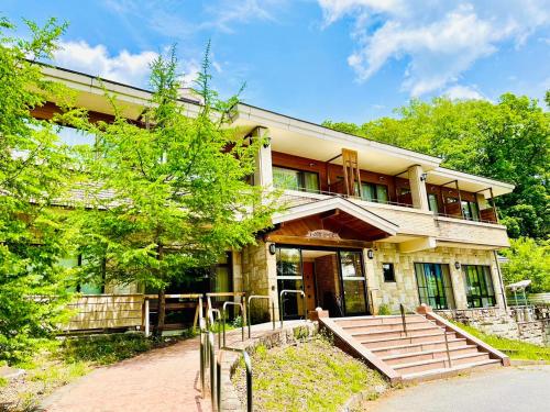 una casa grande con una escalera delante de ella en Lake Side Nikko Hotel en Nikko