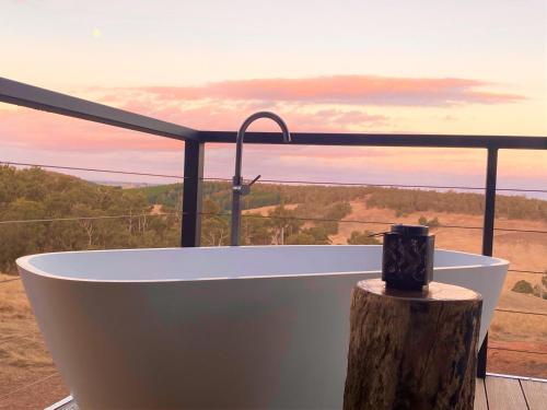 a bath tub on a deck with a view of the ocean at Serenity Gully 