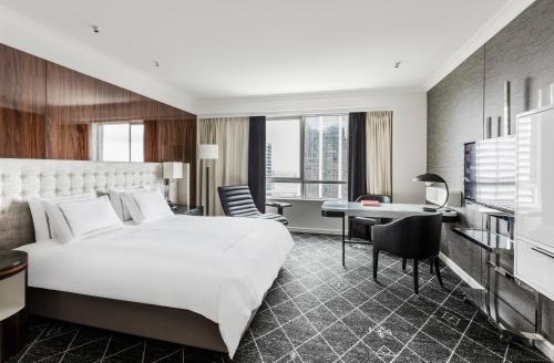 a hotel room with a bed and a desk at Swissotel Sydney in Sydney