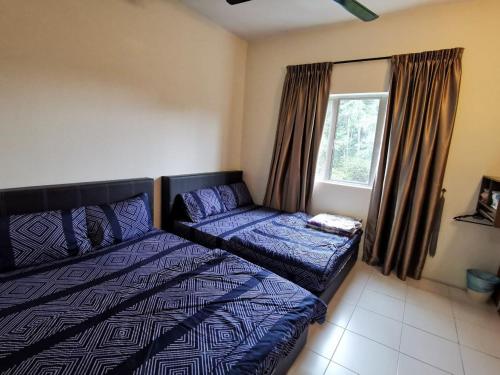 a bedroom with a bed and a couch and a window at Family Stay at Quintet A2-7-3A in Tanah Rata
