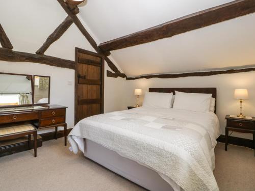 a bedroom with a bed and a dresser and a mirror at Lower Court Byre in Kinsham