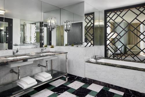uma casa de banho com 2 lavatórios, uma banheira e espelhos em W Miami em Miami