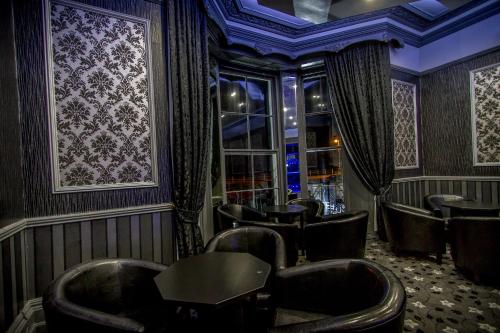 a bar with leather chairs and a table in a room at The Carlton Hotel in Folkestone