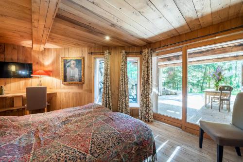 une chambre avec un lit et une grande fenêtre dans l'établissement Chalet Ananda avec Sauna, Baignoire Balnéo et Terrasse, à Chamonix-Mont-Blanc