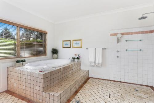 y baño grande con bañera y ducha. en Bella Casa by Latitude South Coast, en Berry