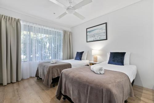 a bedroom with two beds and a window at The Noosa Apartments in Noosa Heads
