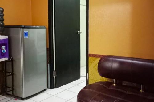 een stoel naast een koelkast in een kamer bij RedLiving Apartemen Modernland - Lian Property Tower Biru in Tangerang