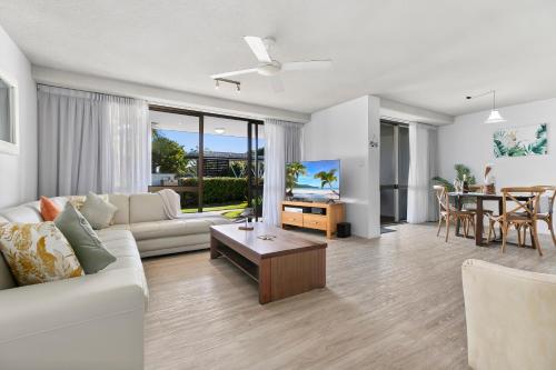 a living room with a couch and a table at The Noosa Apartments in Noosa Heads
