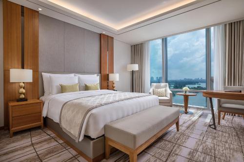 a bedroom with a large bed with a desk and a desk at LOTTE Hotel Yangon in Yangon